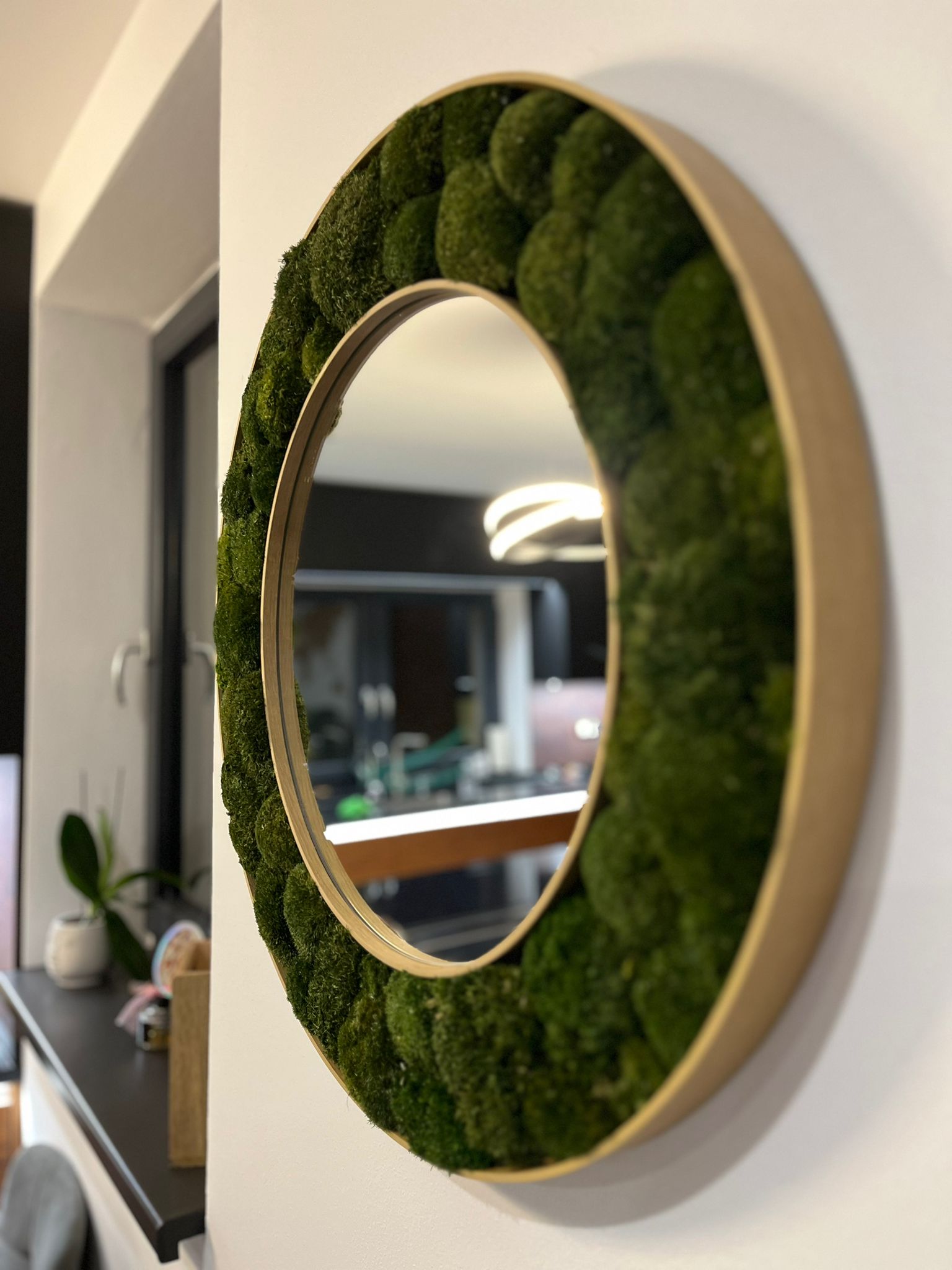 Okrúhle machové zrkadlo S middle dark prináša do priestoru nielen vizuálnu krásu, ale aj pokoj, prírodnú harmóniu a výnimočnú atmosféru, ktorá dodáva interiéru dušu a nikdy neprestane pôsobiť elegantne.